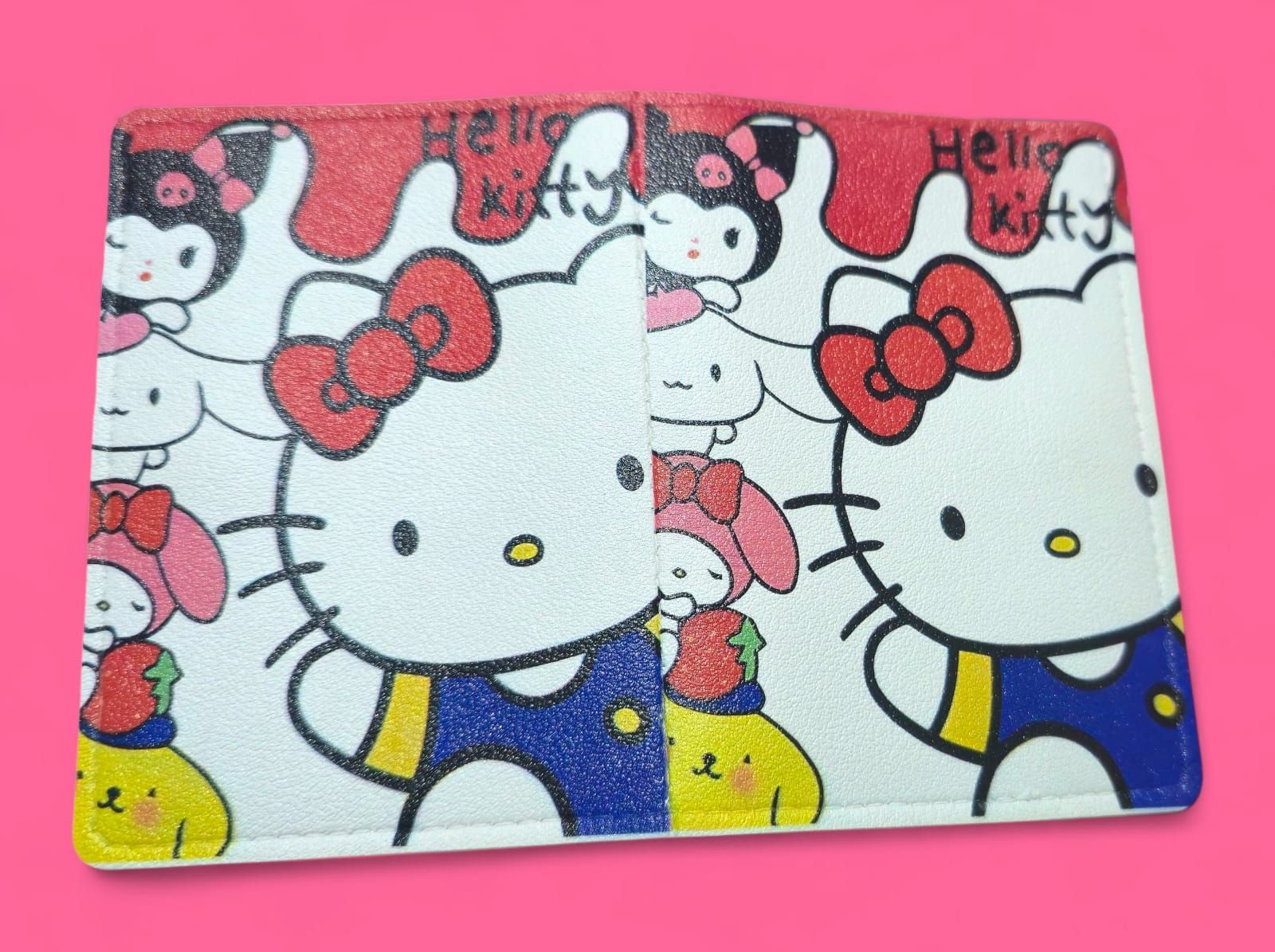 Cartera de Hello Kitty con personajes coloridos sobre fondo rosa.