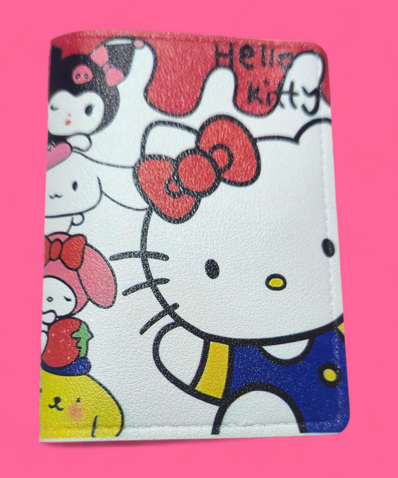 Cartera de Hello Kitty con personajes coloridos sobre fondo rosa.