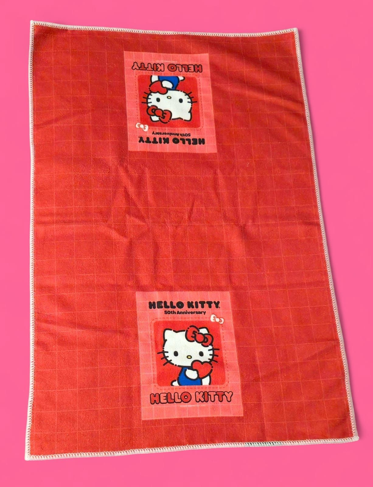 Manta roja de Hello Kitty con dos imágenes cuadradas de Hello Kitty.