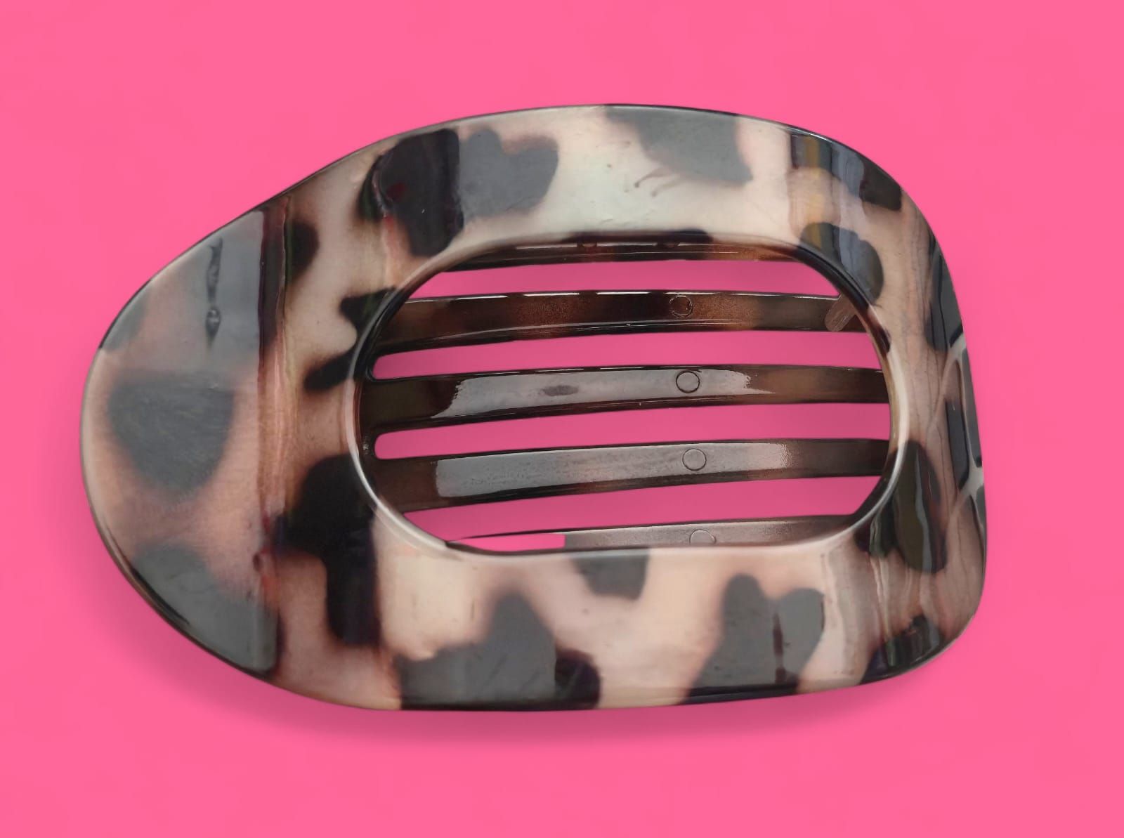Pinza para el pelo con estampado de leopardo y rayas rosas sobre fondo rosa.