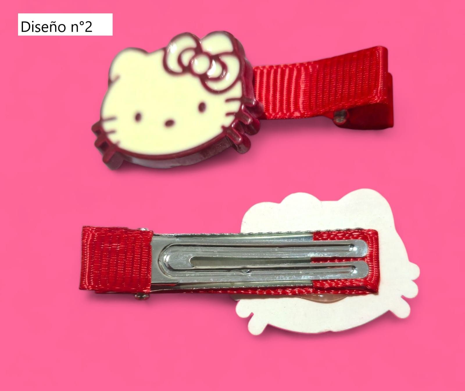Cuatro pinzas para el pelo de Hello Kitty sobre un fondo rosa; dos presentan al personaje y dos son lisas.