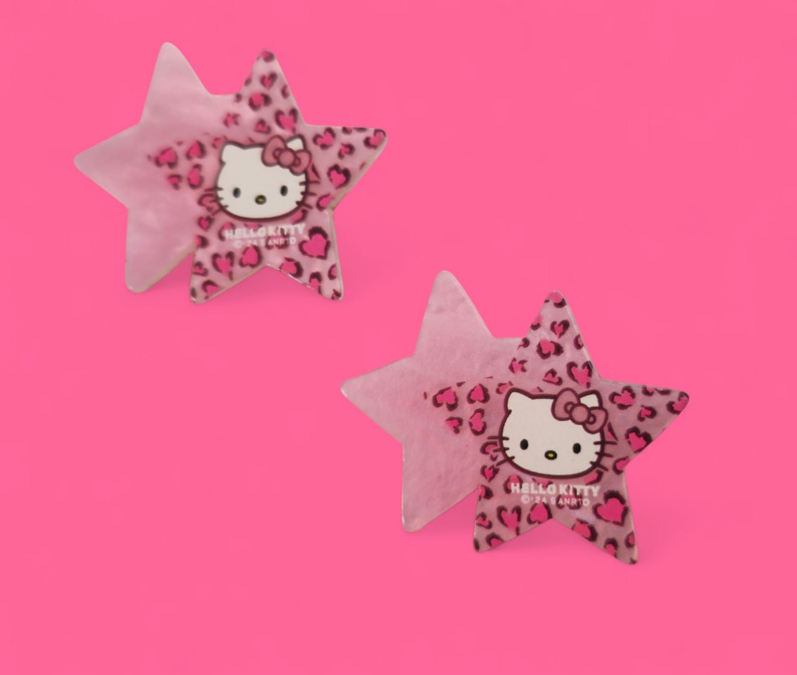 Dos luces nocturnas de Hello Kitty con forma de estrella sobre un fondo rosa.
