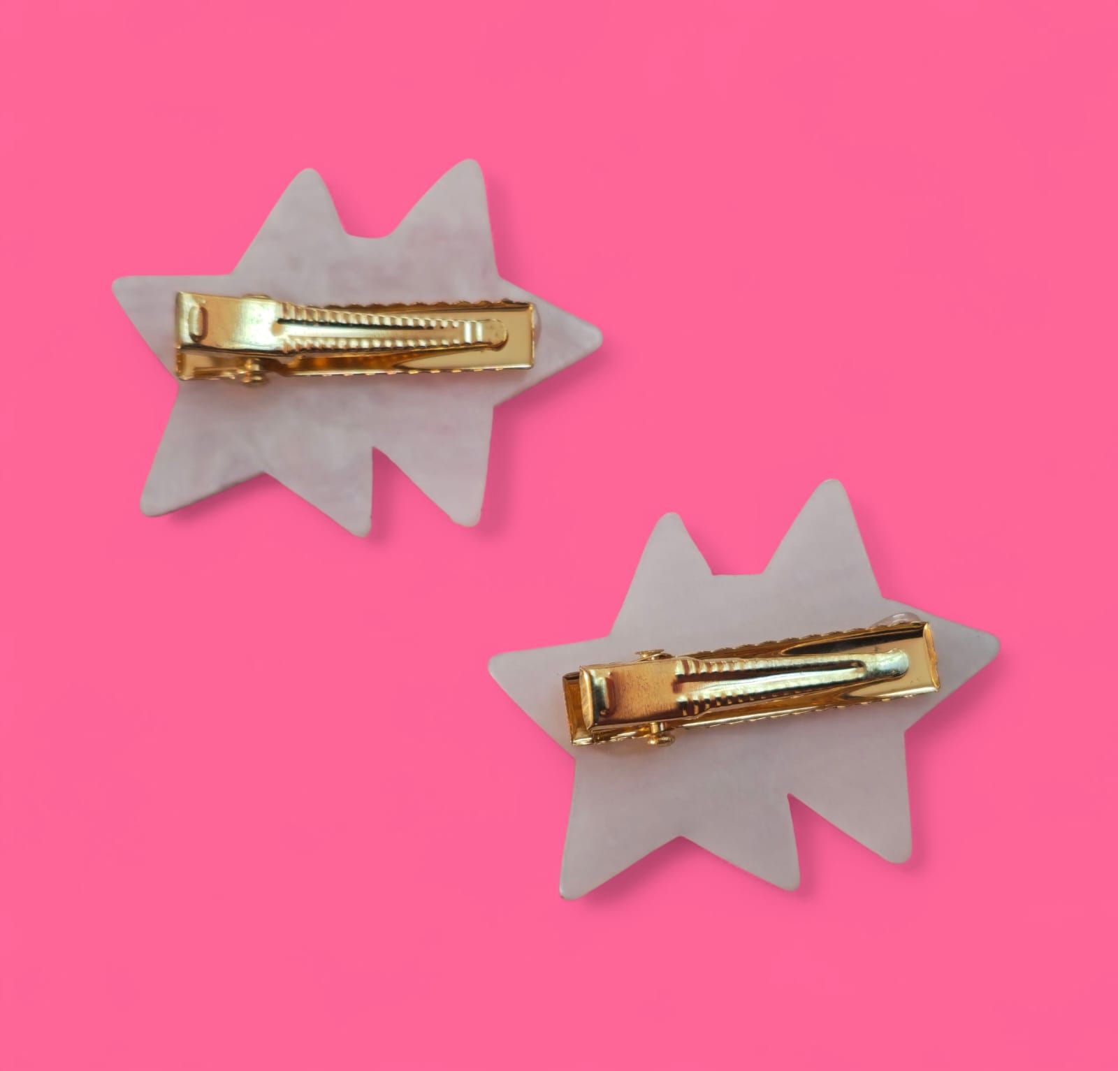 Dos luces nocturnas de Hello Kitty con forma de estrella sobre un fondo rosa.