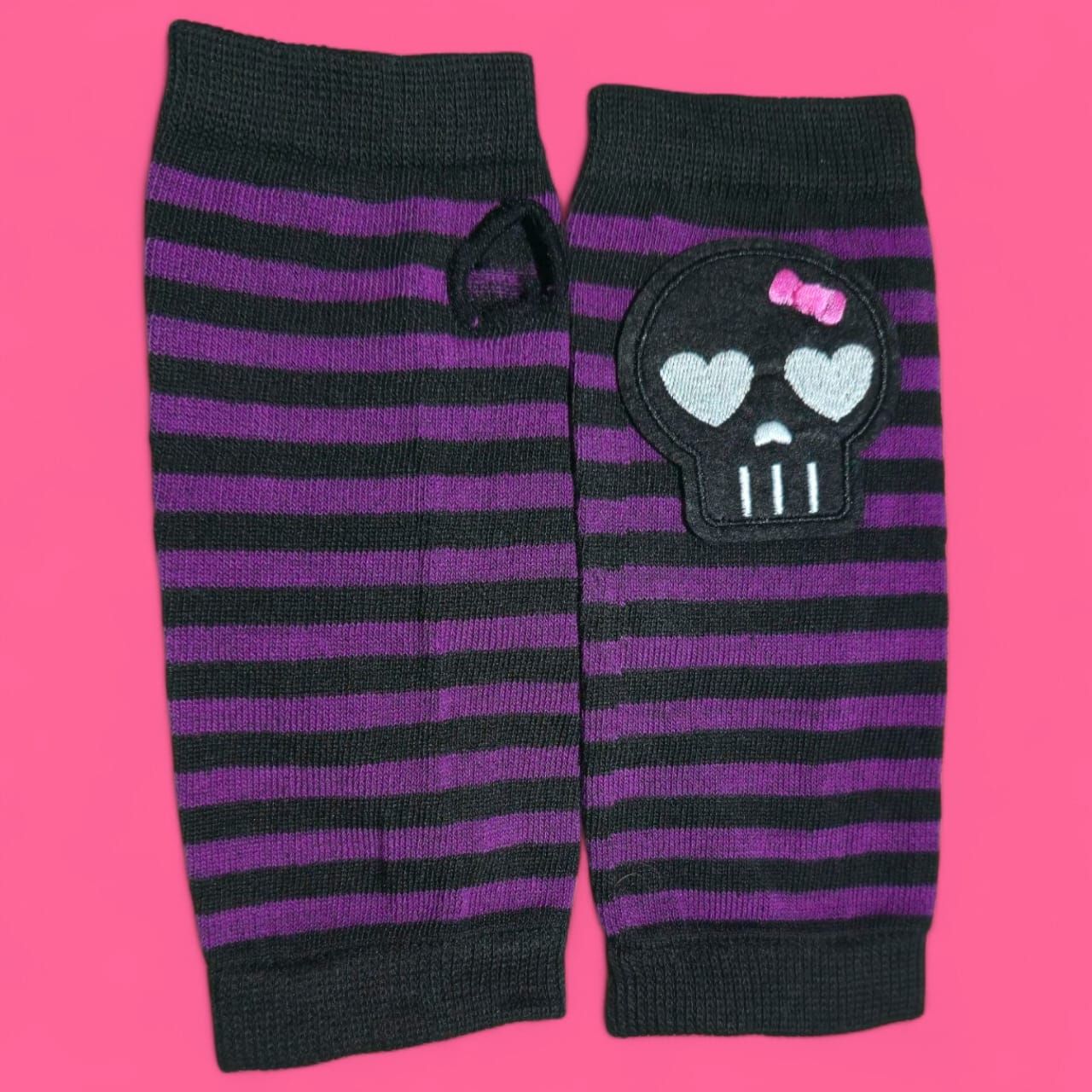 Par de guantes sin dedos a rayas negras y moradas con aplique de calavera.