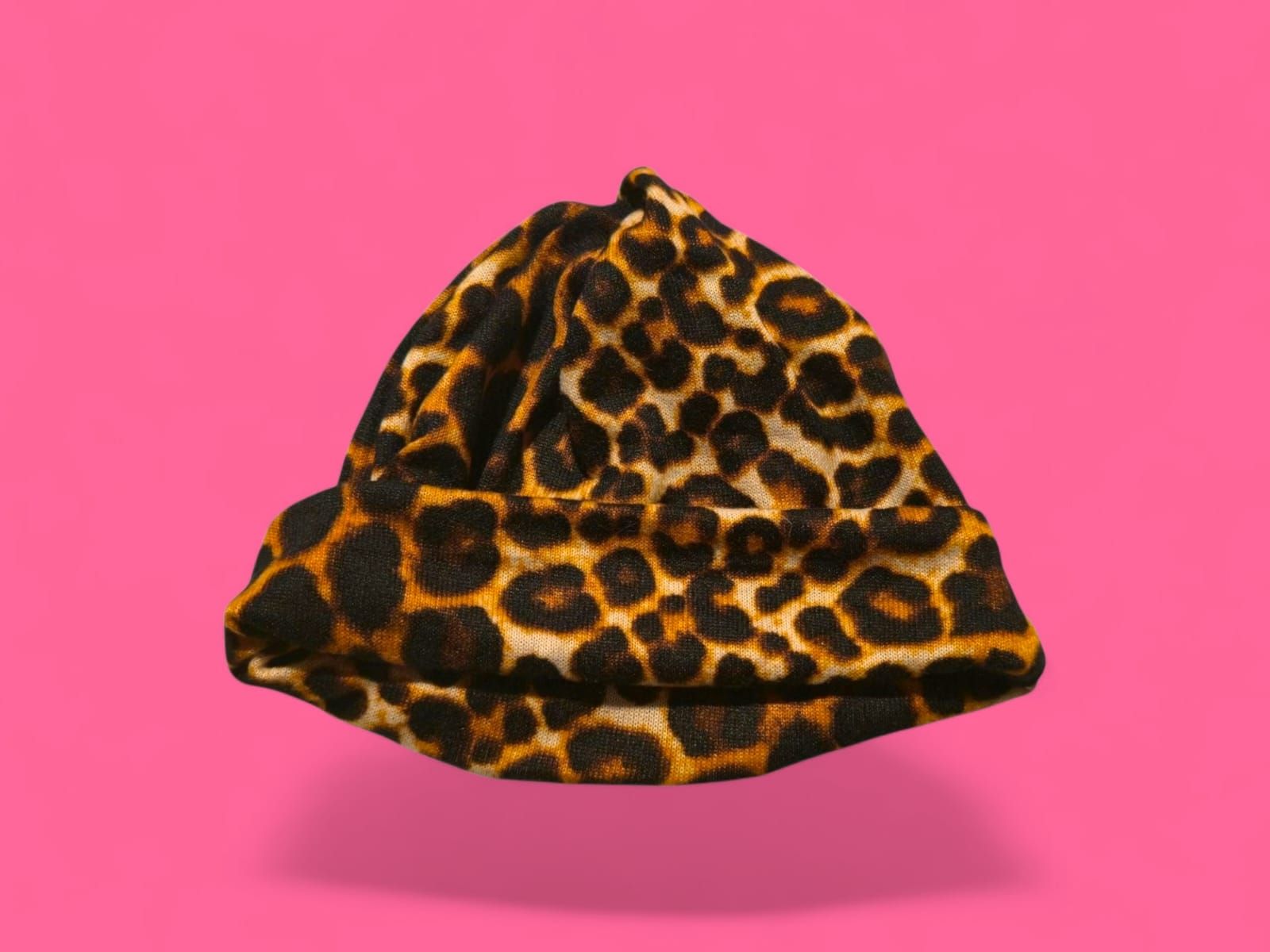 Gorro con estampado de leopardo sobre fondo rosa.