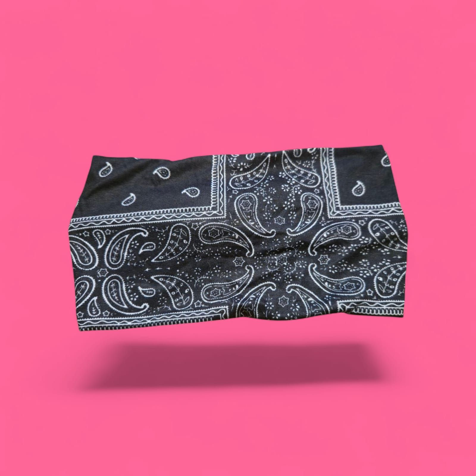 Pantalones cortos con estampado de pañuelo negro sobre fondo rosa.