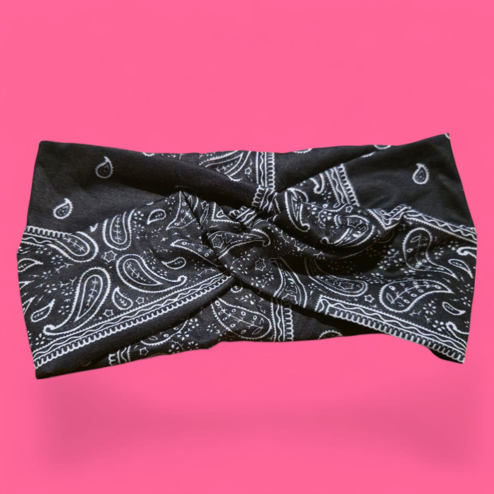Pantalones cortos con estampado de pañuelo negro sobre fondo rosa.