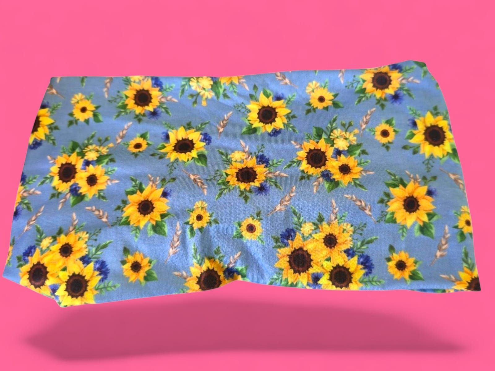 Tela de girasoles sobre fondo azul, con fondo rosa.