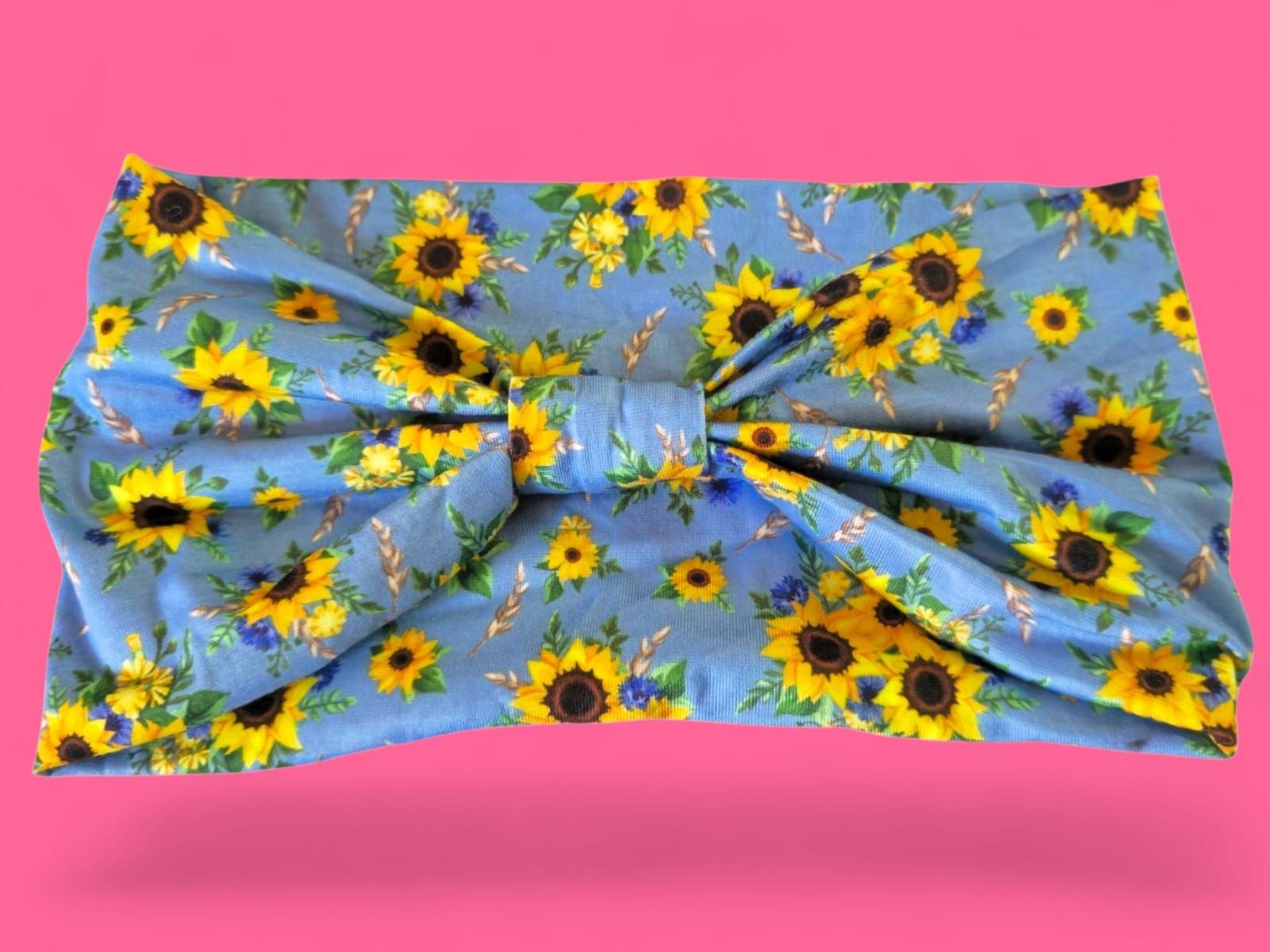 Tela de girasoles sobre fondo azul, con fondo rosa.