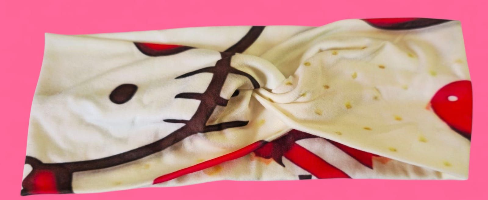 Almohada con temática de Hello Kitty con corazón rojo sobre fondo rosa.