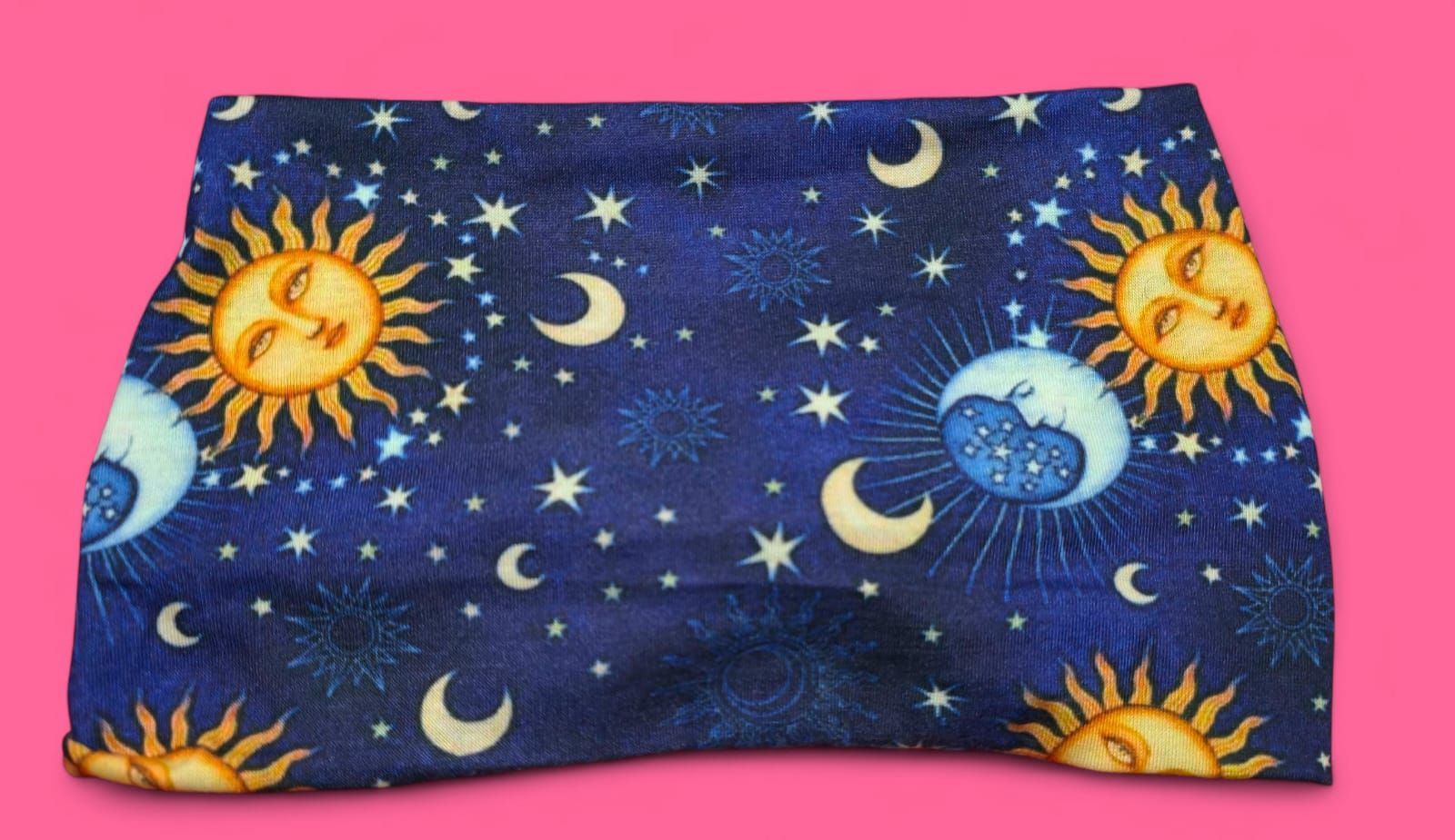 Tela azul con diseño celestial de soles, lunas y estrellas.