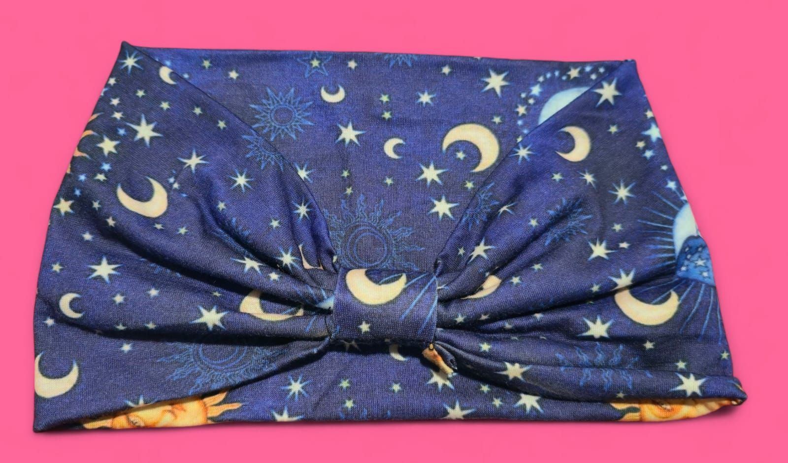 Tela azul con diseño celestial de soles, lunas y estrellas.