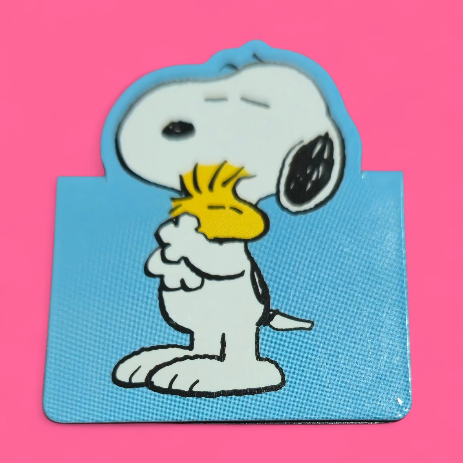 Snoopy y Woodstock abrazándose, fondo azul claro, contorno rosa y fondo.