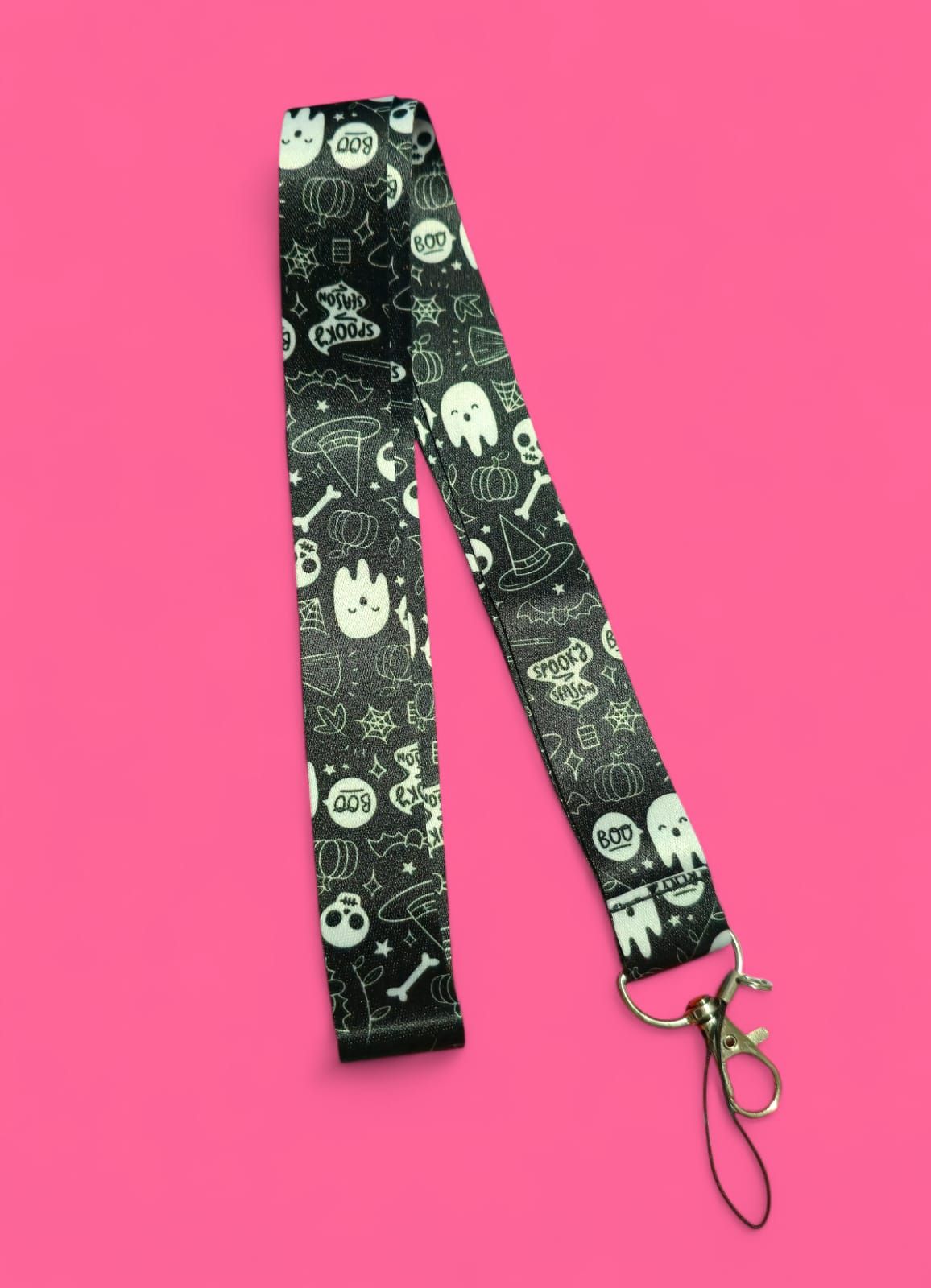 Cordón negro con estampado blanco de temática de Halloween, sobre fondo rosa.