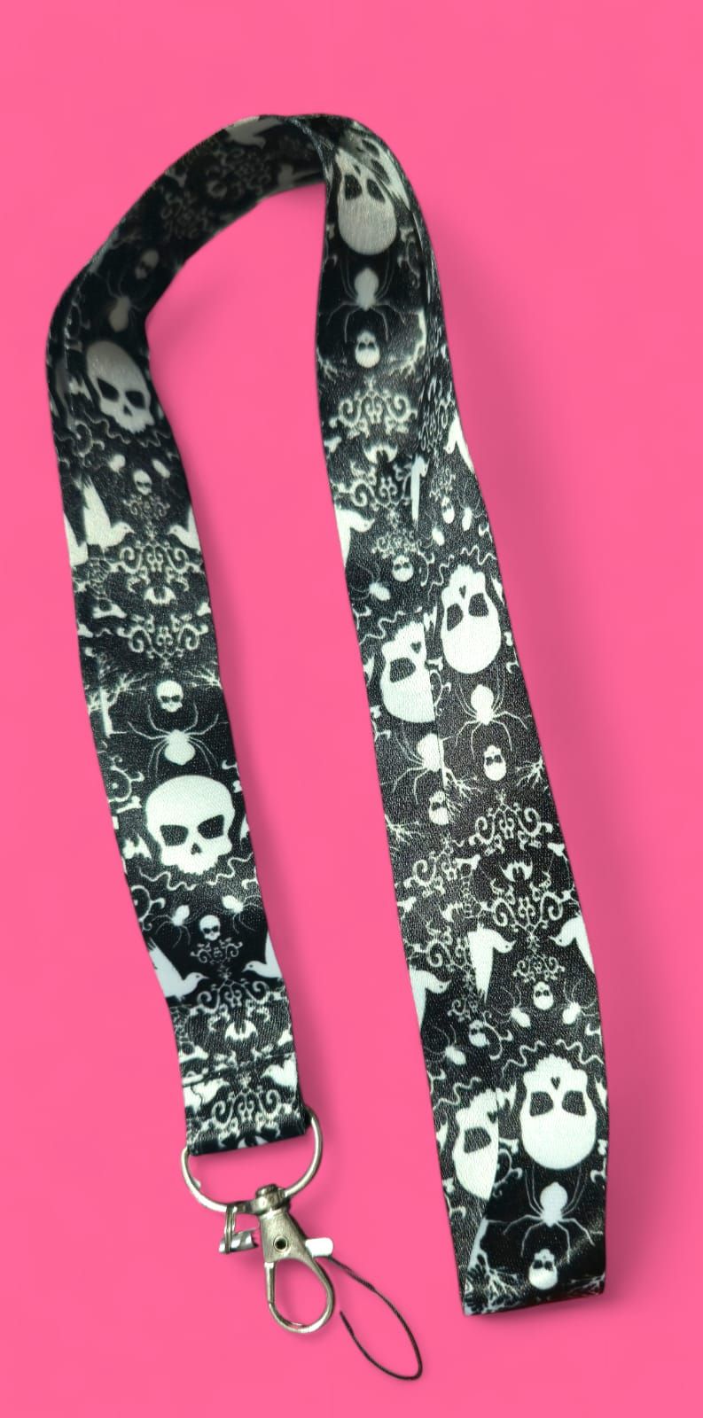 Cordón con estampado de calavera en blanco y negro sobre un fondo rosa.