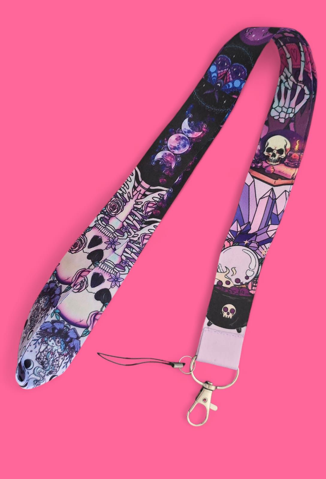 Cordón con estampado colorido de calaveras, cristales y huesos sobre fondo rosa.