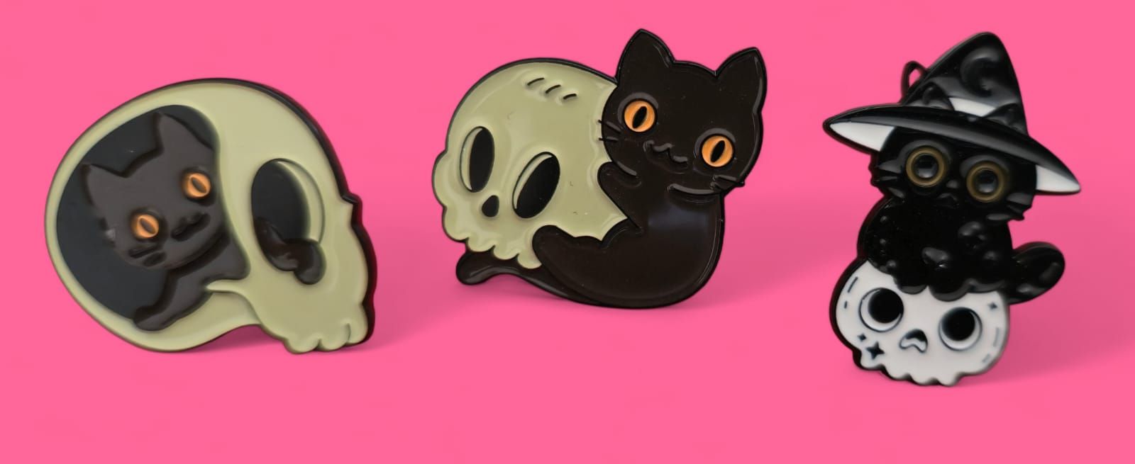 Tres pines de esmalte: gato en calavera, gato abrazando calavera, gato con sombrero de bruja en calavera.