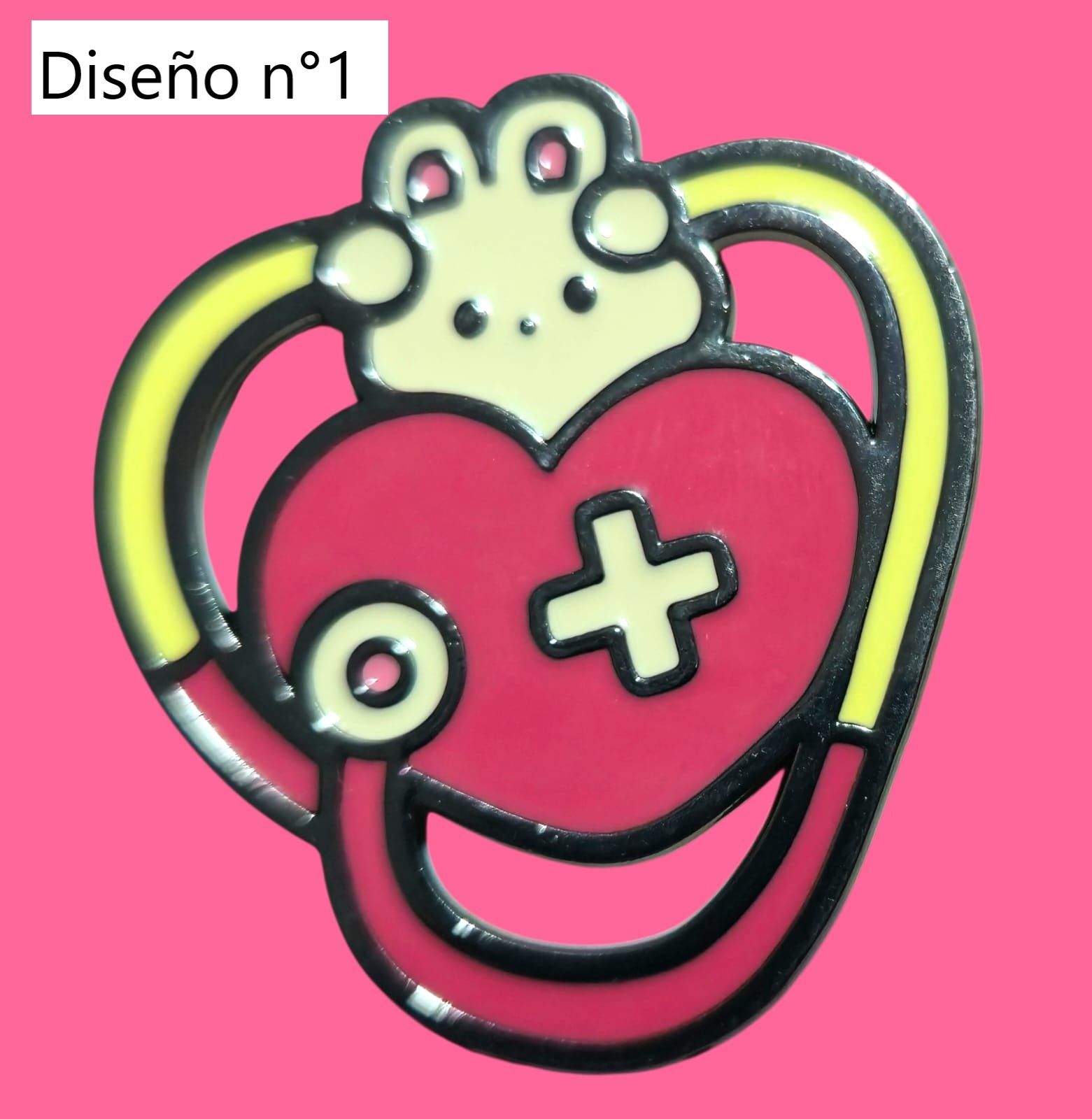 Tres pins de temática médica sobre fondo rosa: estetoscopio, monitor cardíaco y microscopio.