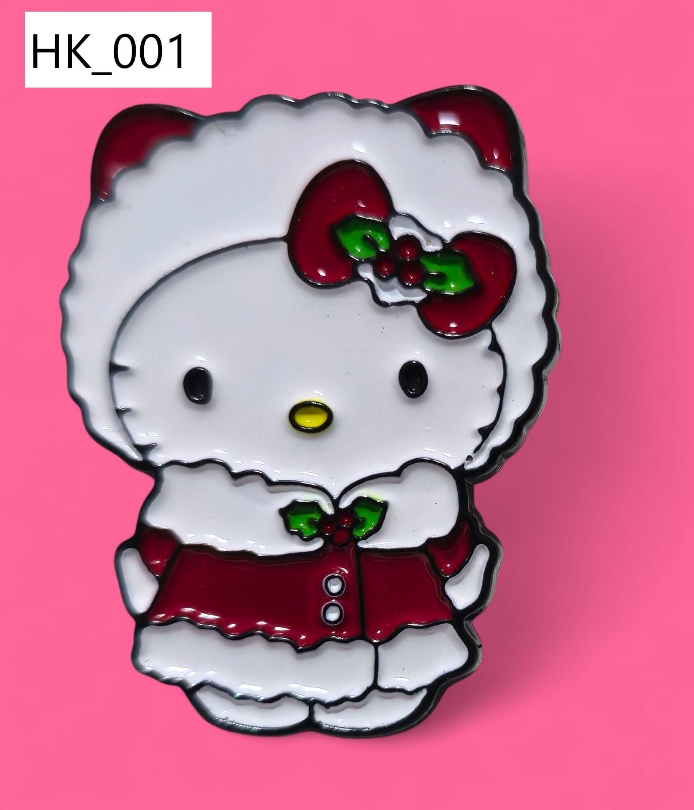 Pin de esmalte de Hello Kitty con traje de Papá Noel, lazo rojo y acebo.