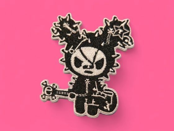 Parche de conejito punk rock en blanco y negro con una guitarra sobre fondo rosa.