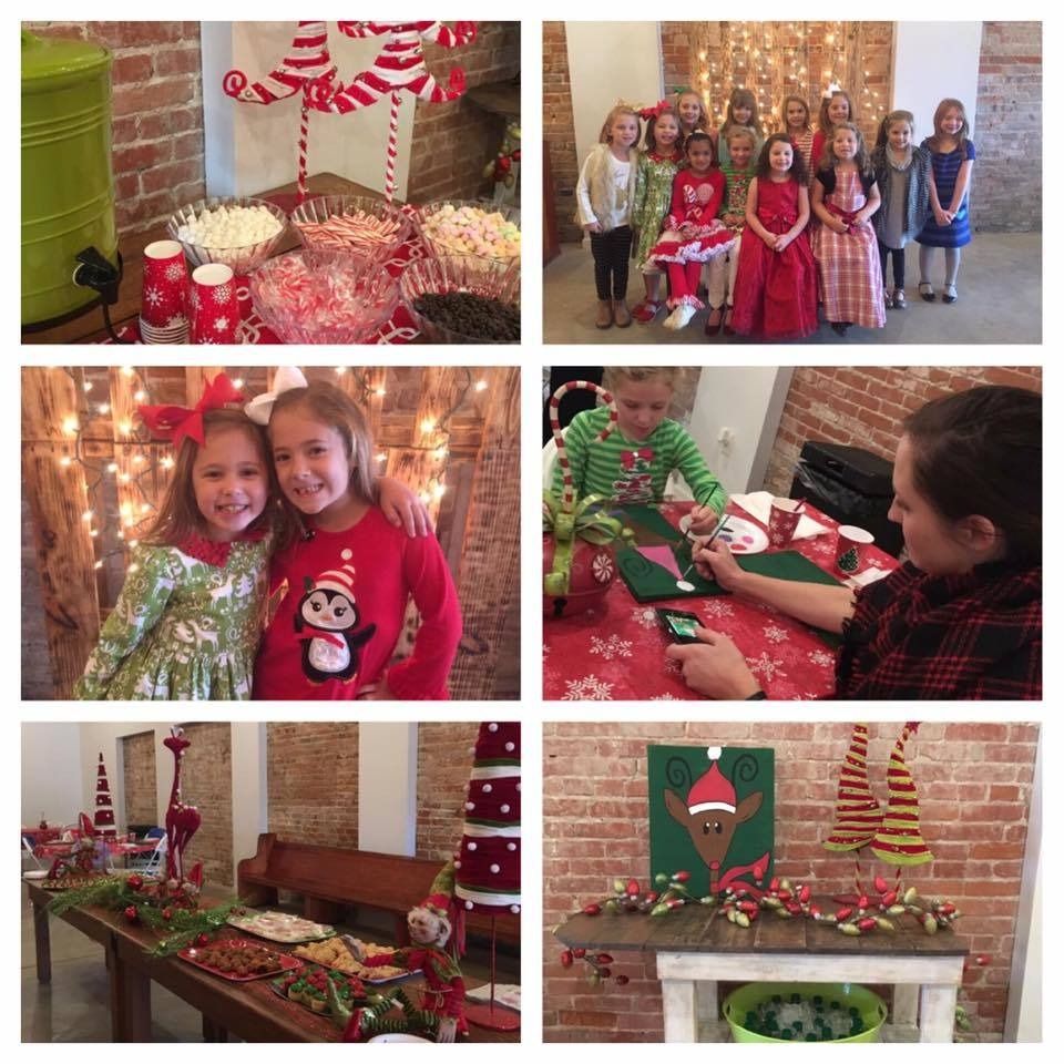 Holiday craft table with candy canes, wrapped gifts, children in festive outfits, and Christmas fireplace décor