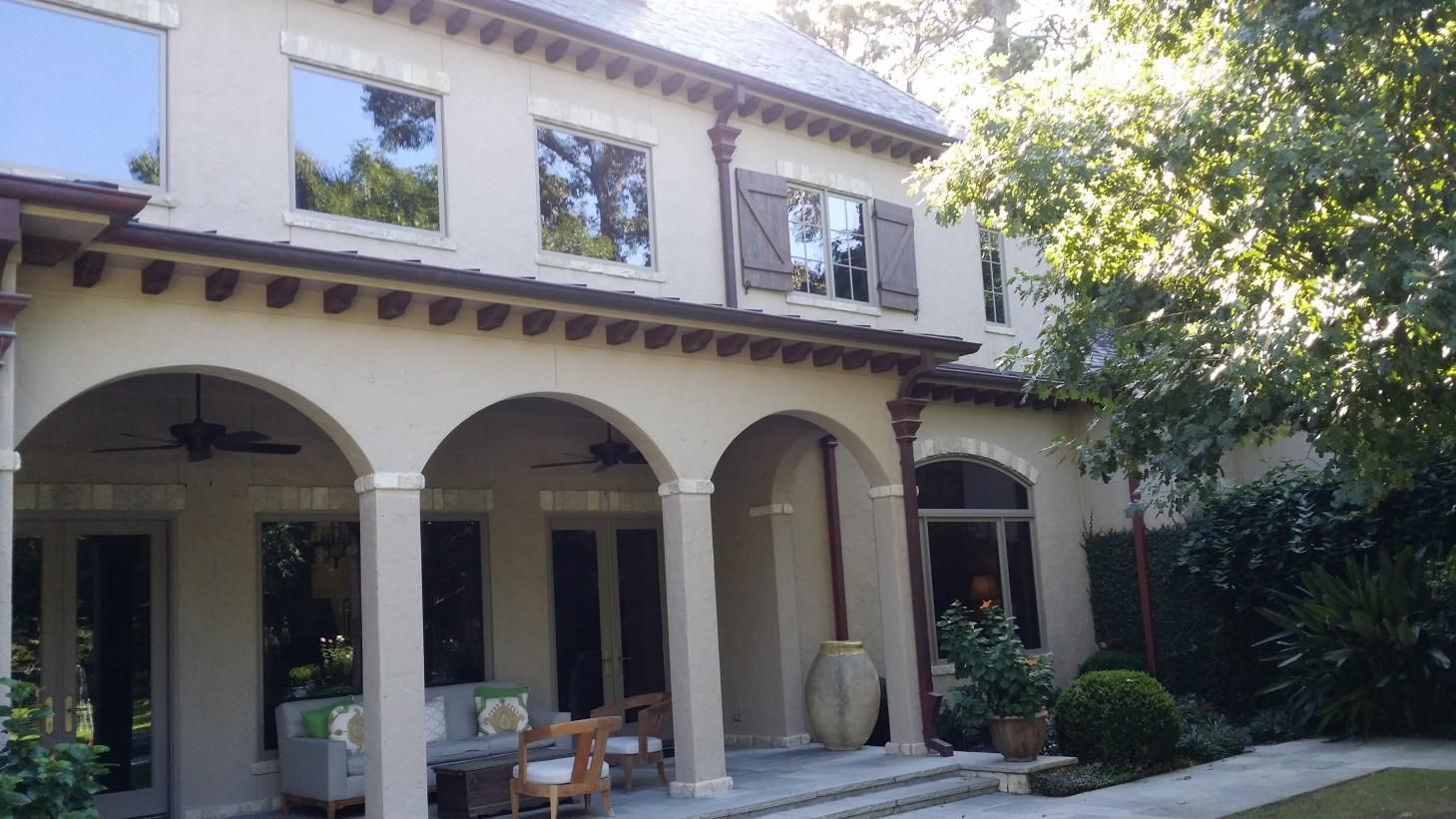Two windows with green shutters on an orange building.