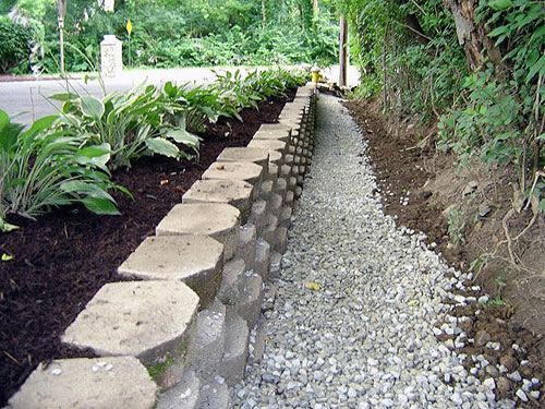 A stone wall is being built next to a gravel path.