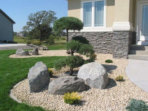 A house with a rock garden in front of it