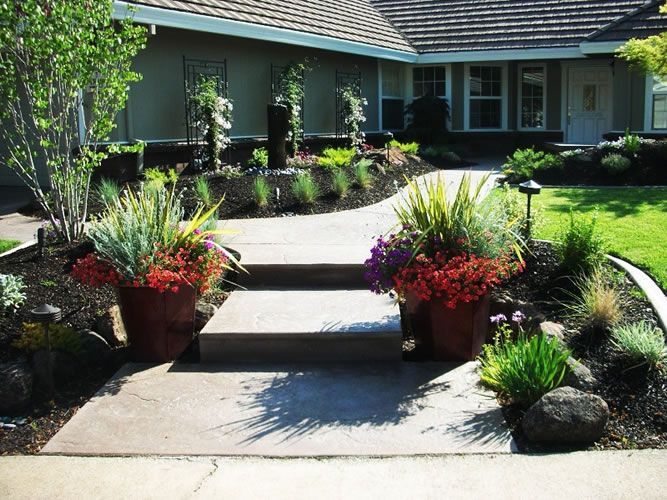 A house with a walkway and potted plants in front of it