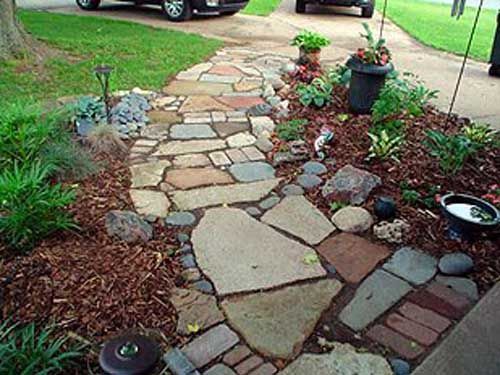 A stone walkway with a car parked on the side of it