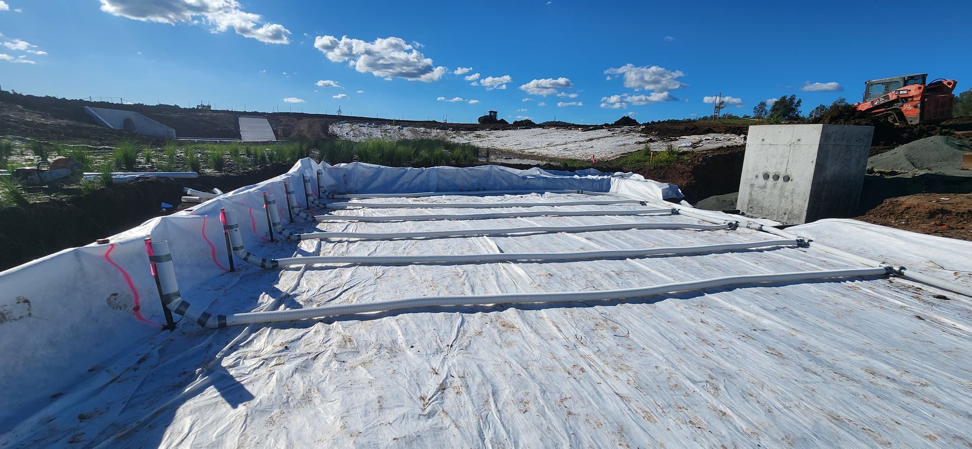 Construction Site With White Tarp, Concrete Barriers, and Metal Beams — Earthmoving in Maitland, NSW