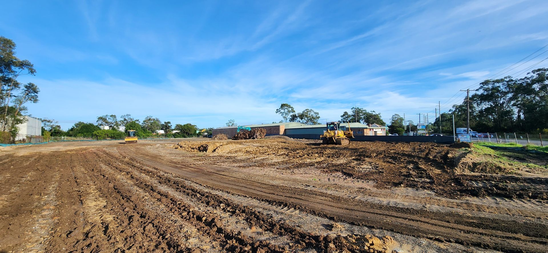 Bulldozer is Loading a Dump Truck with Gravel on a Construction Site — Earthmoving in Maitland, NSW