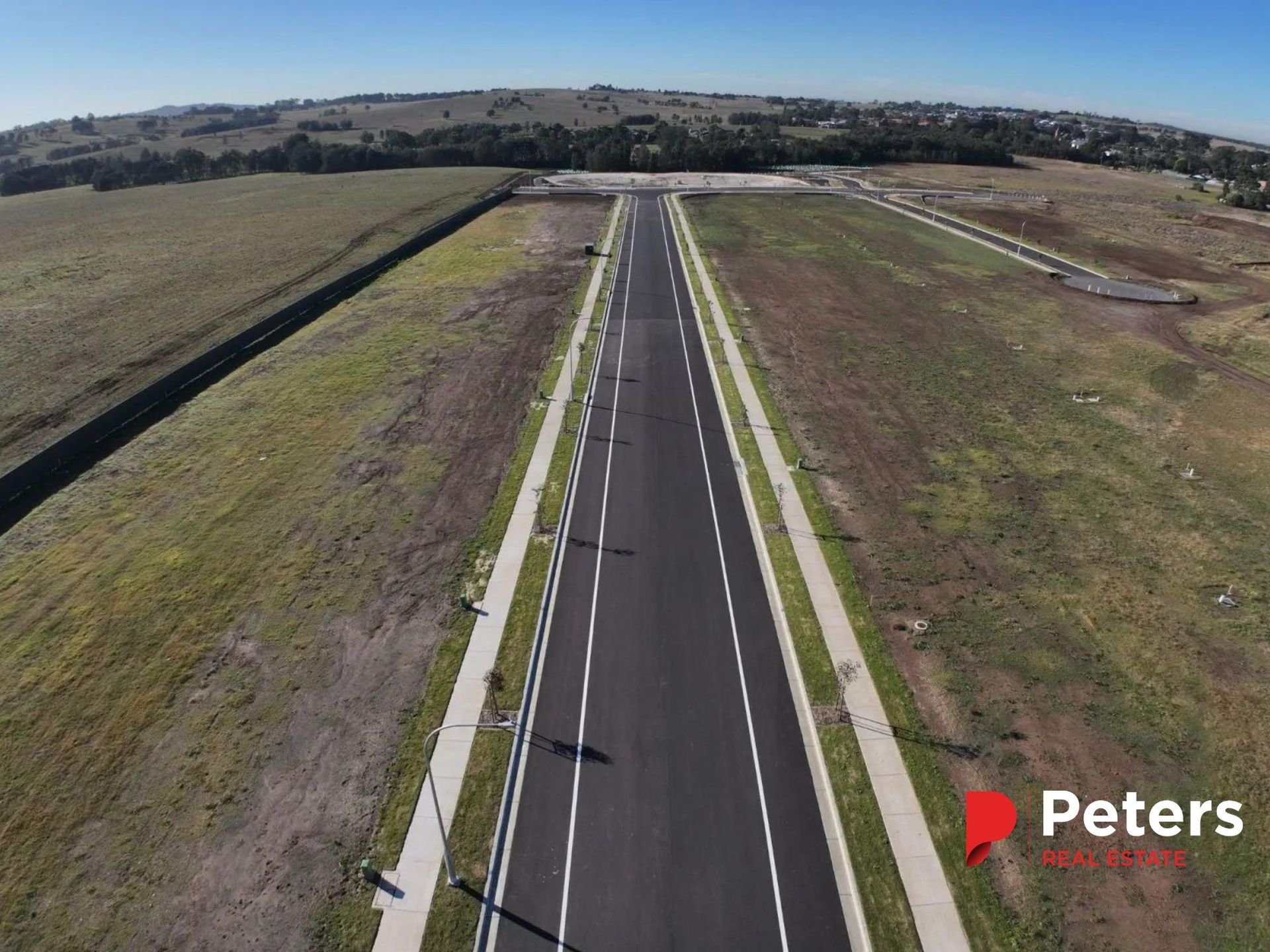 An Aerial View of a Newly Paved Road Through an Empty Field, Ready for Development — Earthmoving in Maitland, NSW