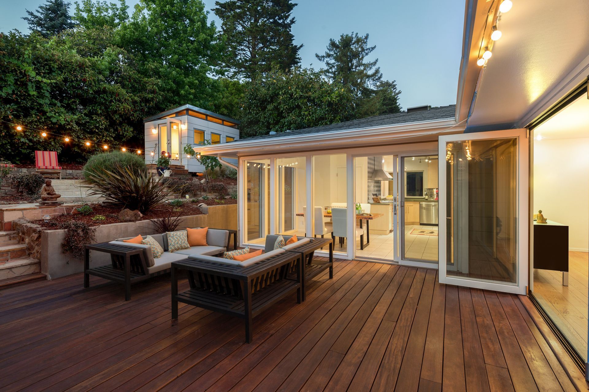 Modern deck patio with outdoor seating and sliding glass doors at dusk Modern deck patio with outdoor seating and sliding glass doors at dusk