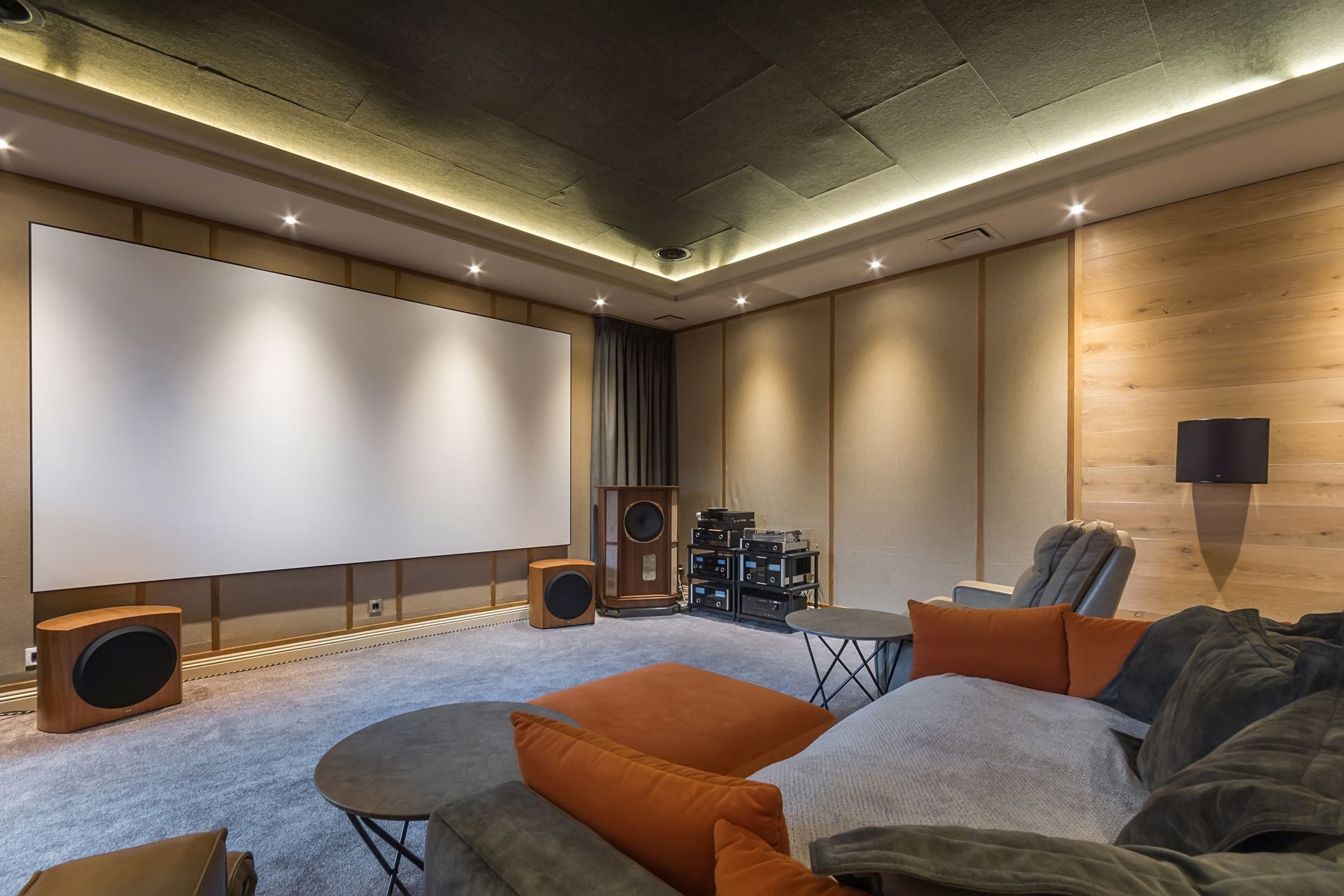 Modern home theater with large screen, sectional sofa, speakers, and ambient ceiling lighting Modern home theater with large screen, sectional sofa, speakers, and ambient ceiling lighting