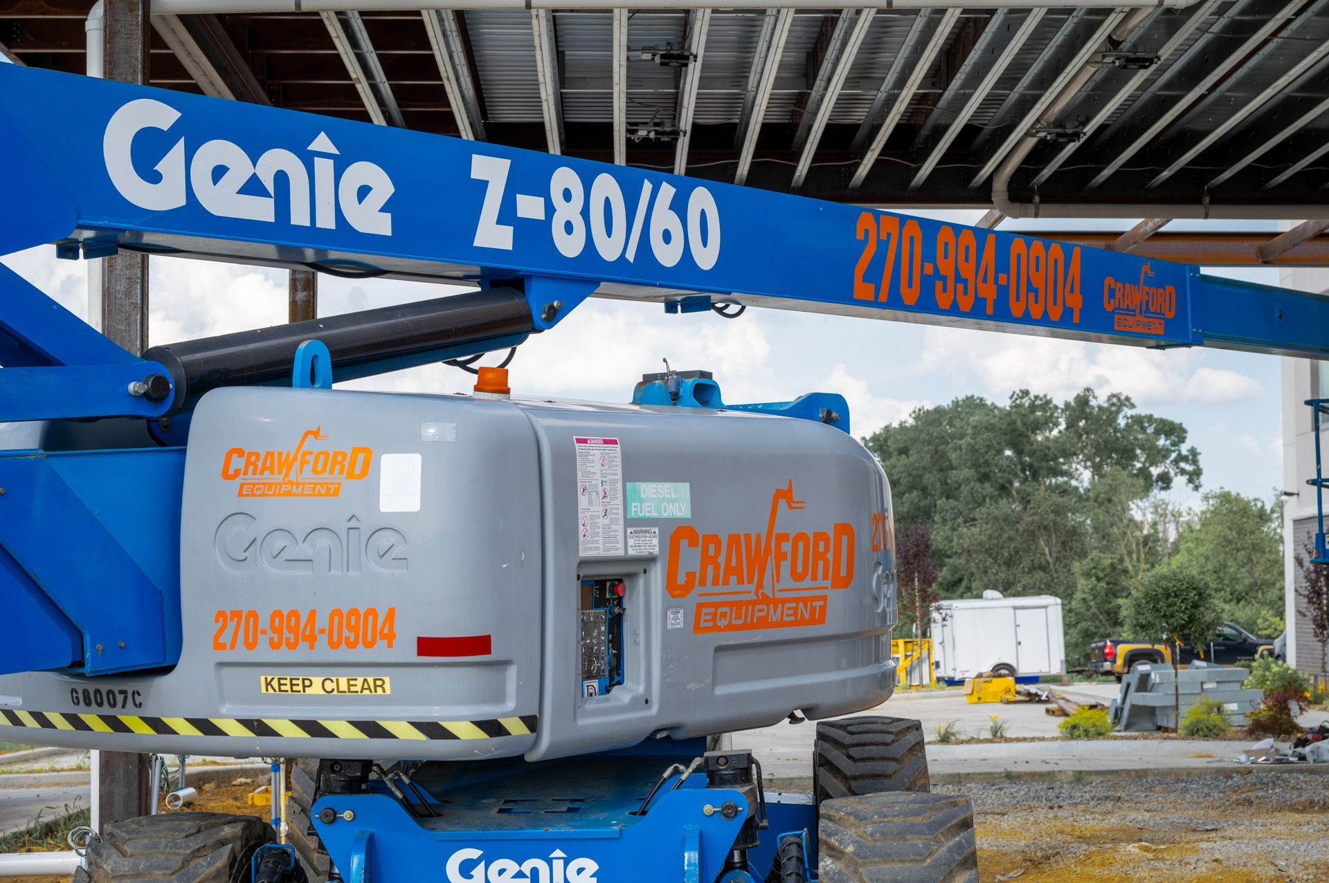 Blue Genie Z-80/60 boom lift with Crawford branding at a construction site.