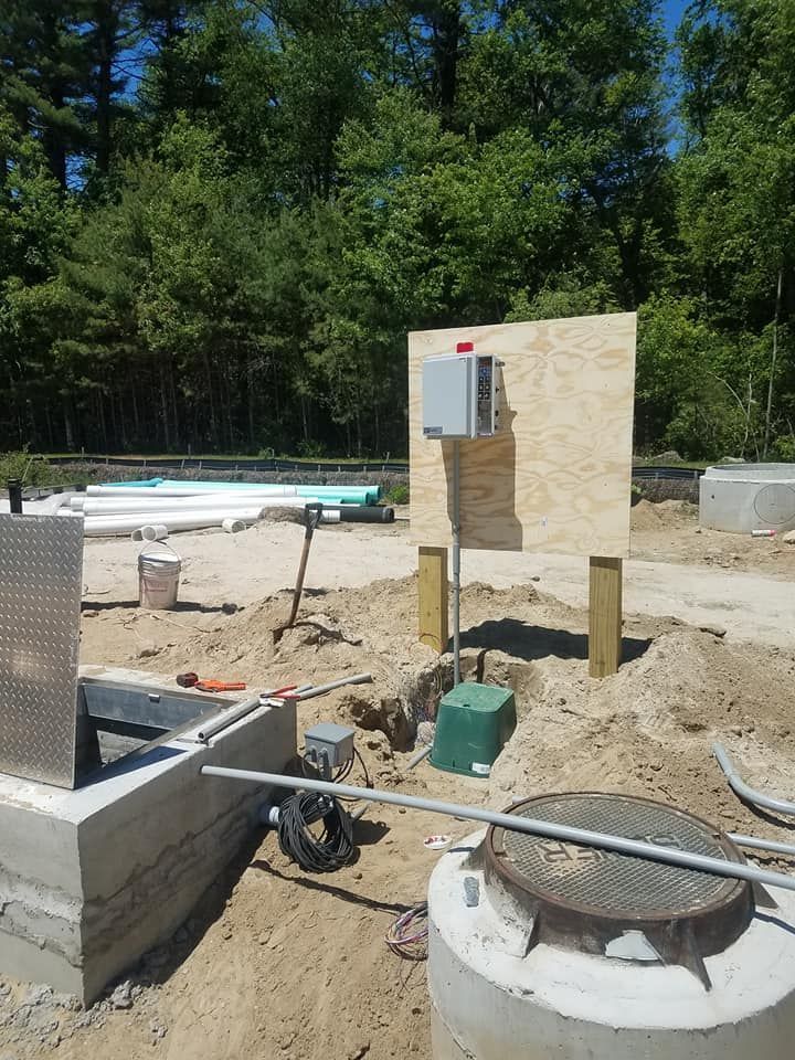 A manhole cover is sitting in the middle of a dirt field.