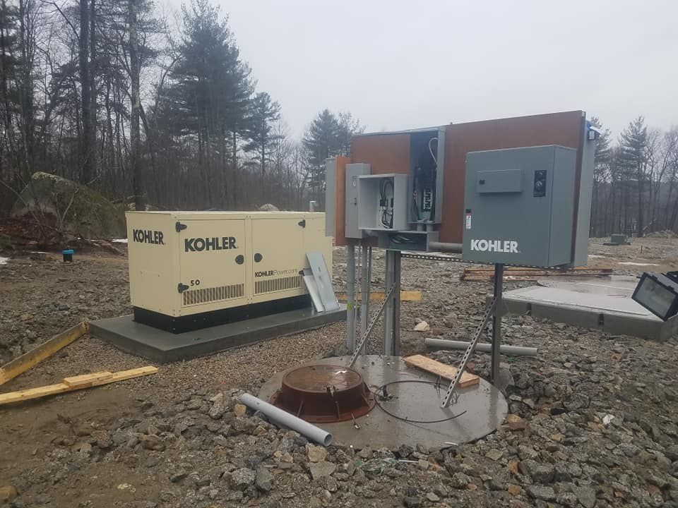 A kohler generator is sitting on top of a pile of rocks.