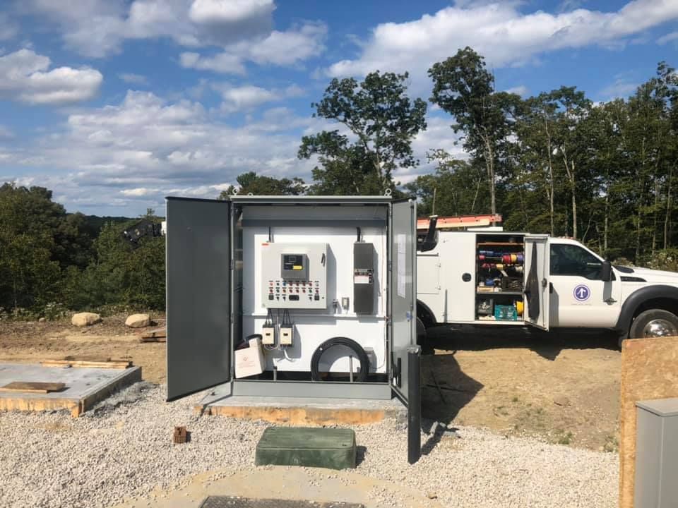 A white truck is parked next to a large electrical box.