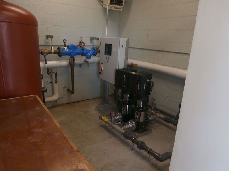 A room with a lot of pipes and a control panel