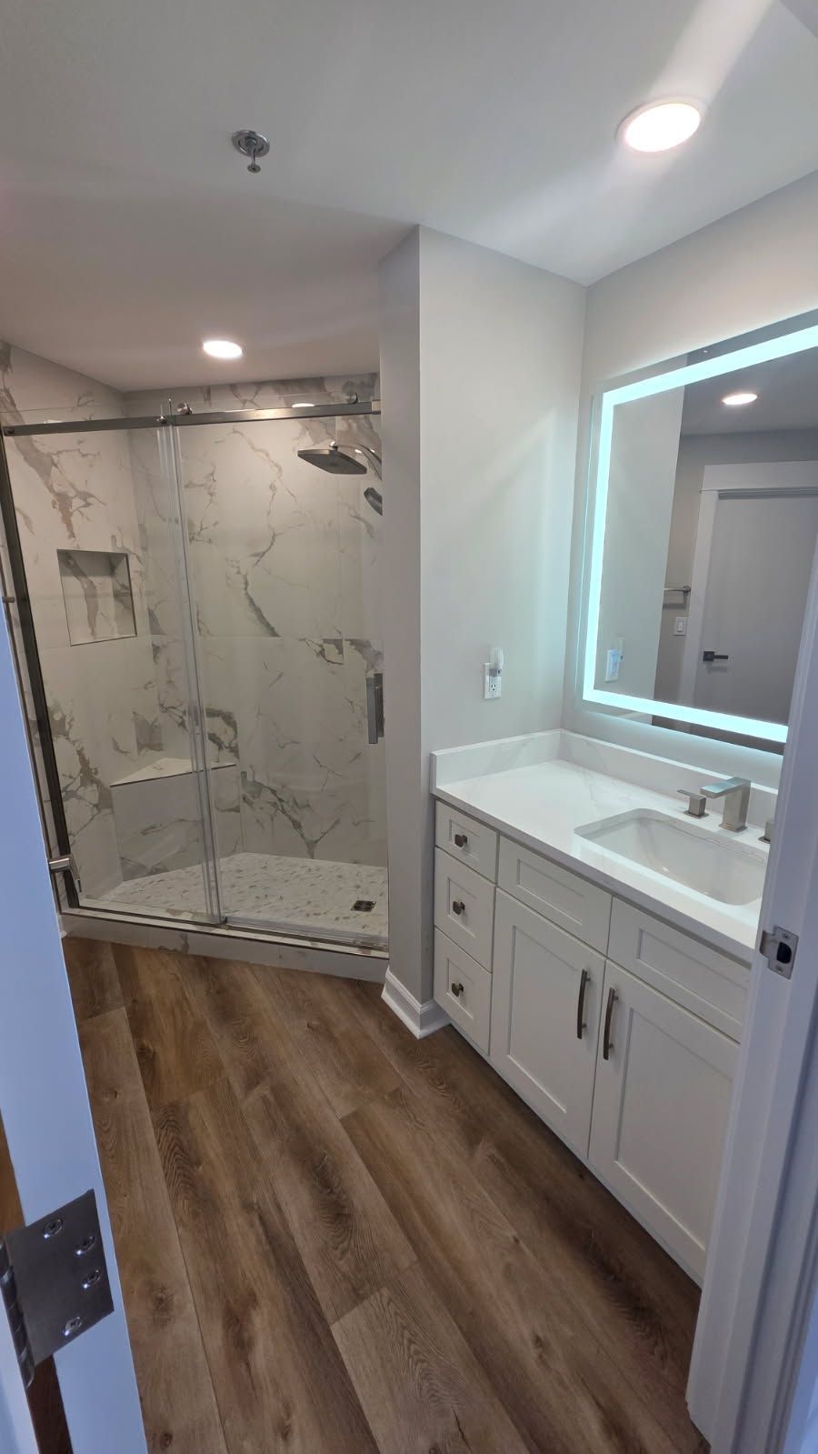 Kitchen with white cabinets, large island with bar stools, and stainless steel appliances.