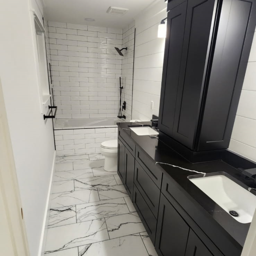 Kitchen with light gray cabinets, island with granite countertop, and stainless steel appliances.