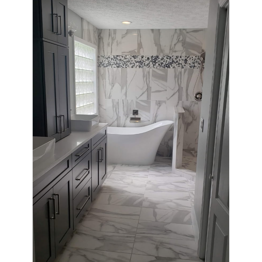 Kitchen with white cabinets, large island with bar stools, and stainless steel appliances.