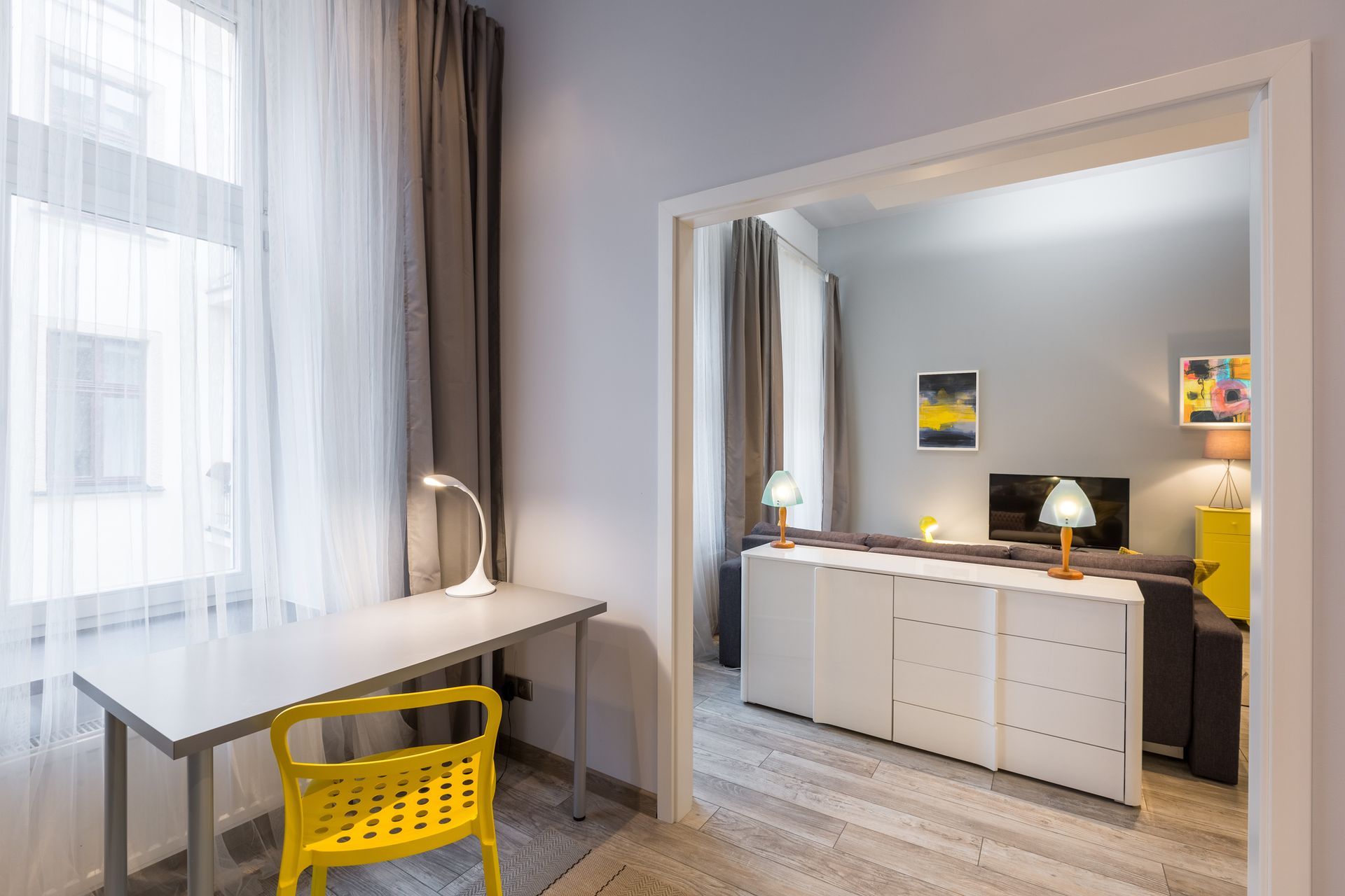 A room with a desk and a yellow chair in it.