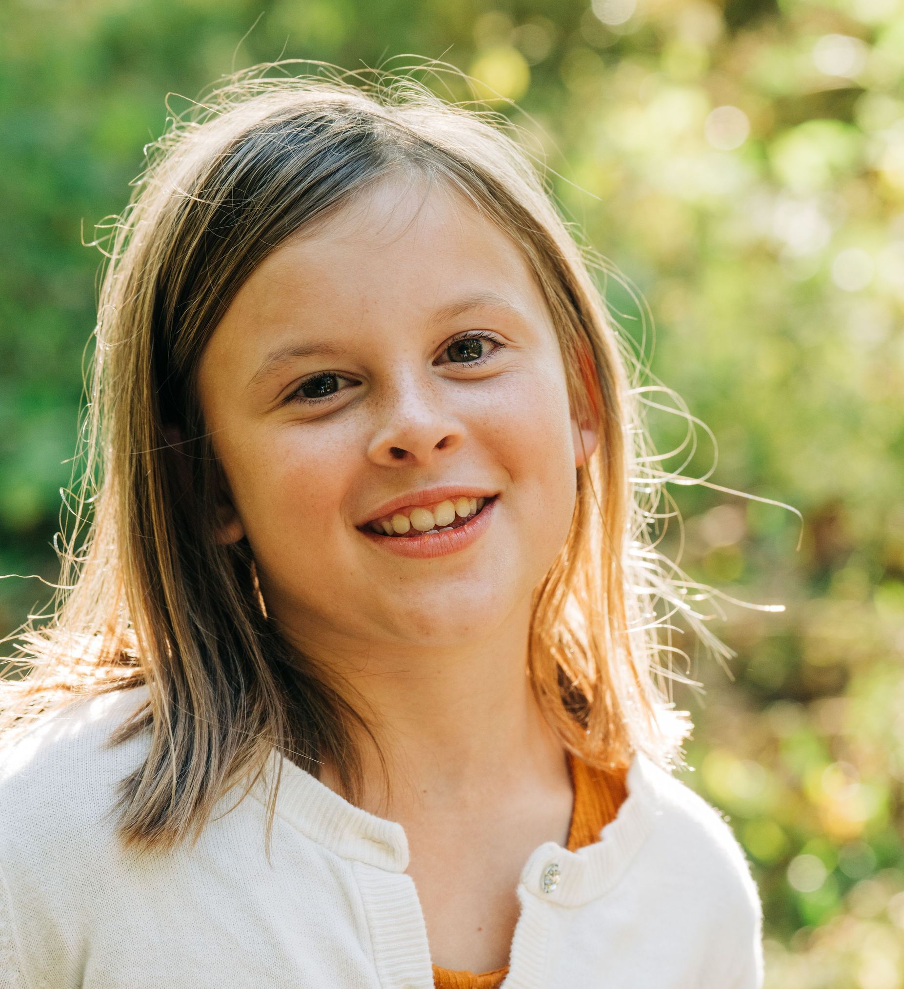 A little boy and girl are sitting on the grass talking on a toy phone.