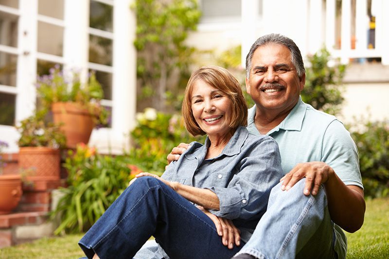 White elderly couple embracing each other at the park