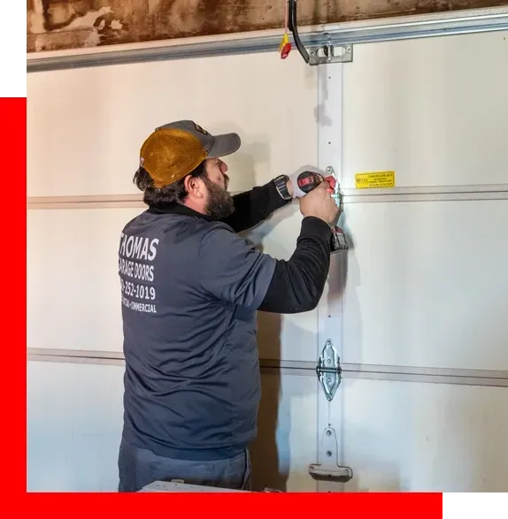 A man is measuring a garage door with a tape measure.