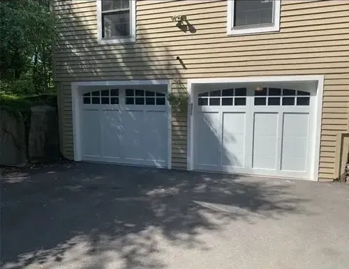 Stylish dark wood garage door installation. Expert residential garage door service for durability and curb appeal.