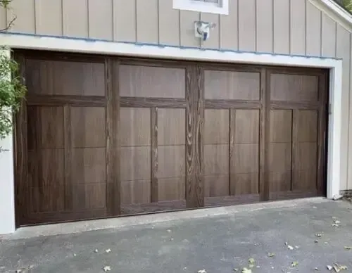 Elegant white garage door installation with decorative windows. Quality residential garage door replacement and service.