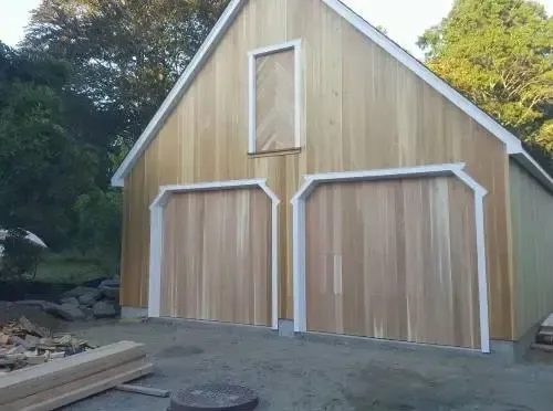 Custom wooden garage door installation for a barn-style building. Professional residential and commercial garage solutions.